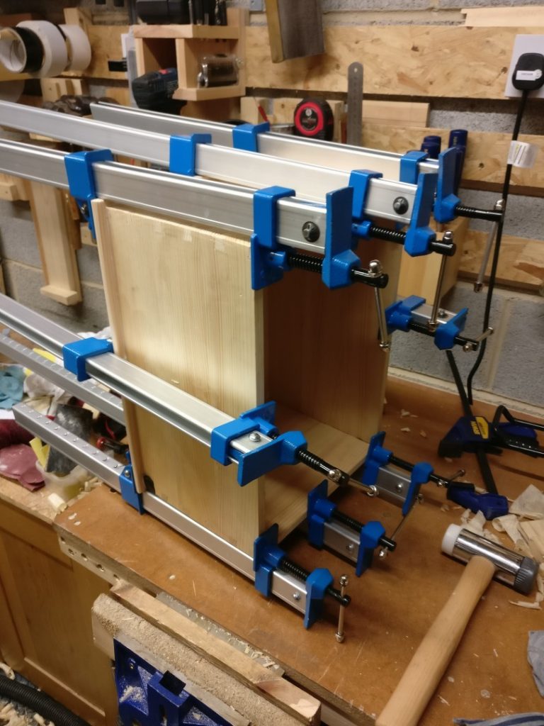 A large pine dovetail box being glued onto its base