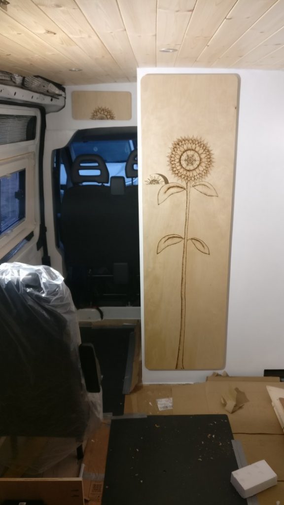 The bathroom door, which is made from Birch plywood with a sunflower design that Amy did using pyrography